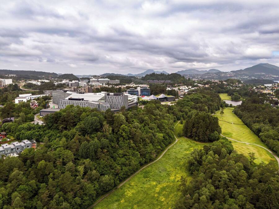 Vista aérea de un campus con edificios modernos, un campo de golf y zonas verdes circundantes.