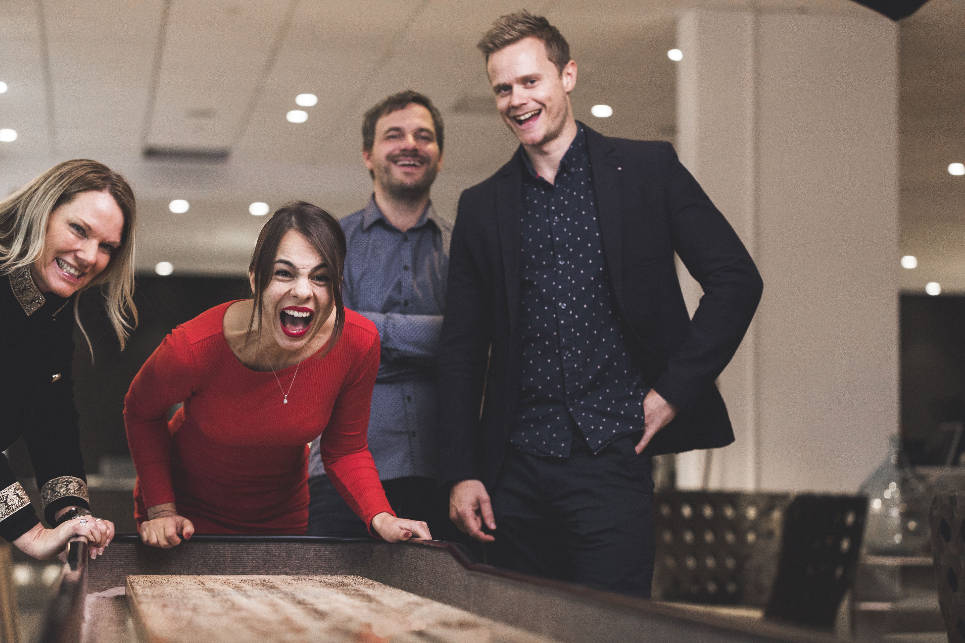 A group of people standing around a table in a modern indoor setting.
