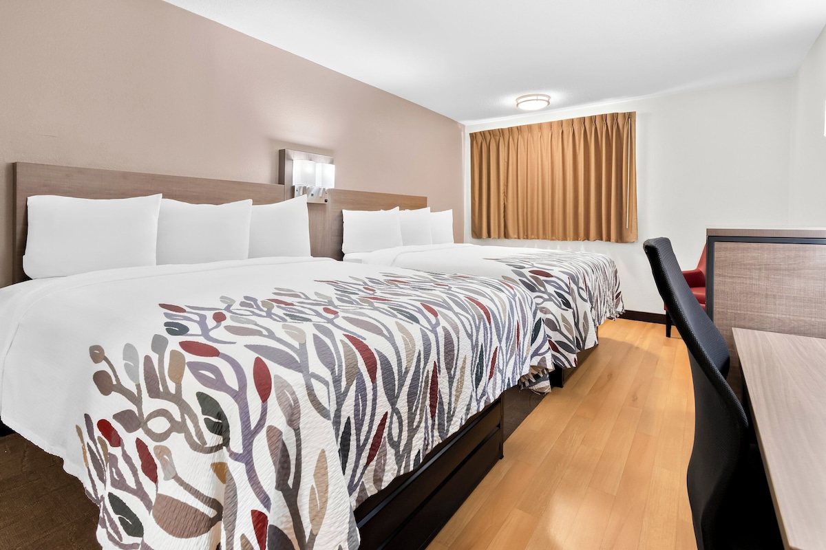 Ein Hotelzimmer mit einem großen Bett, einem Schreibtisch und einem Sessel.