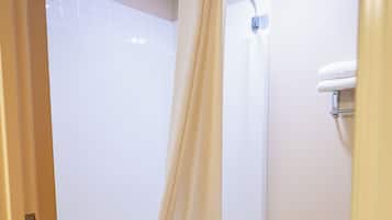 A bathroom with a bathtub, toilet, and a shower curtain.