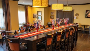 A long dining table with chairs, decorated with a red, white, and blue table runner and American flag ornaments. - Savanna Inn & Suites (Savanna)