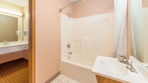 Un baño con bañera, lavabo y espejo.