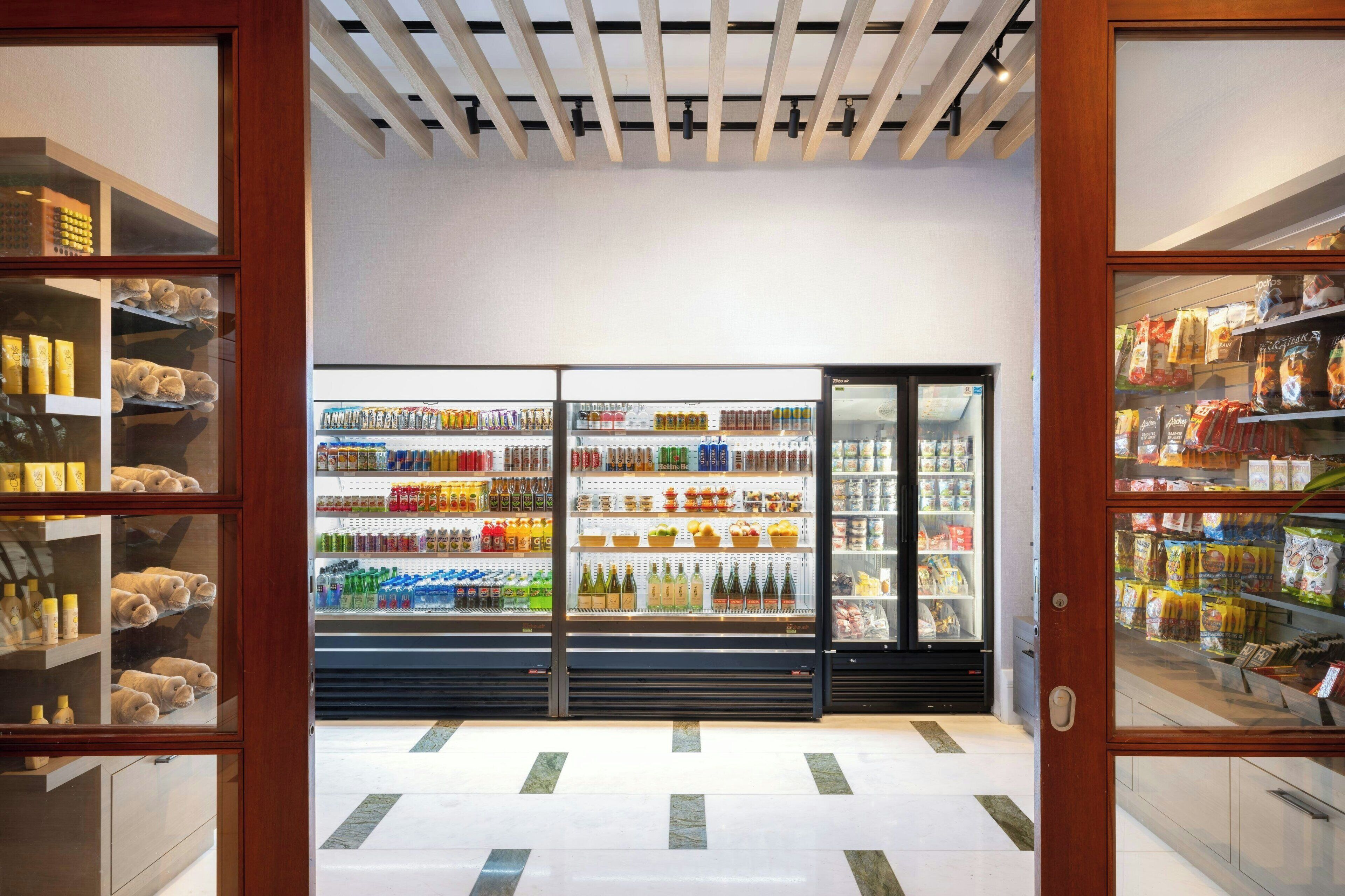 Un supermercado moderno con secciones refrigeradas y estantes repletos de diversos productos.