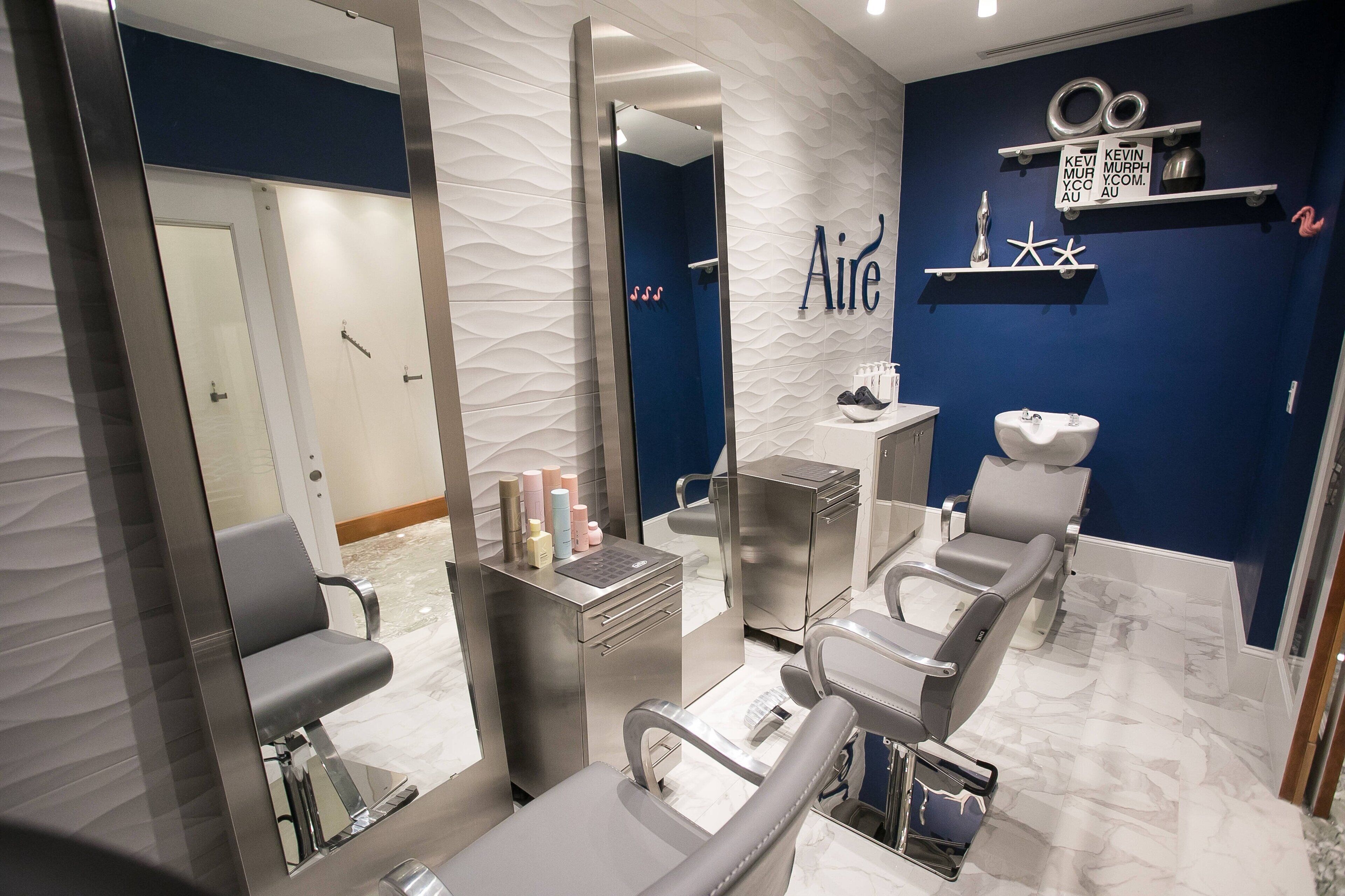 A modern dental clinic with a blue accent wall, a reception desk, and multiple dental chairs.