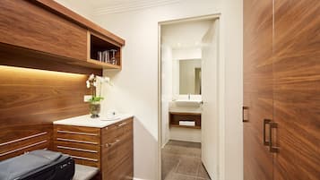 Un baño moderno con tocador de madera, un espejo y zona de ducha.