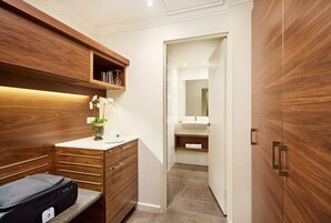A modern bathroom with a wooden vanity, a mirror, and a shower area.