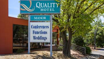 A sign for Quality Hotel, indicating it offers Manor accommodations and services for Conferences, Functions, and Weddings.
