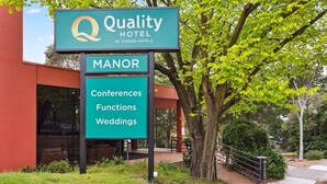 Un letrero de hotel que indica 'Quality Hotel by Choice Hotels' y 'Manor', mostrando el nombre y tipo de hotel.
