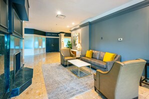A modern lobby with a sofa, armchairs, a coffee table, and a fireplace. - Chateau Cartier Hotel & Resort, an Ascend Collection Resort (Gatineau)