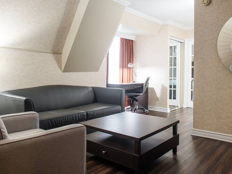 A modern living room with a sectional sofa, a coffee table, and a desk with a chair.