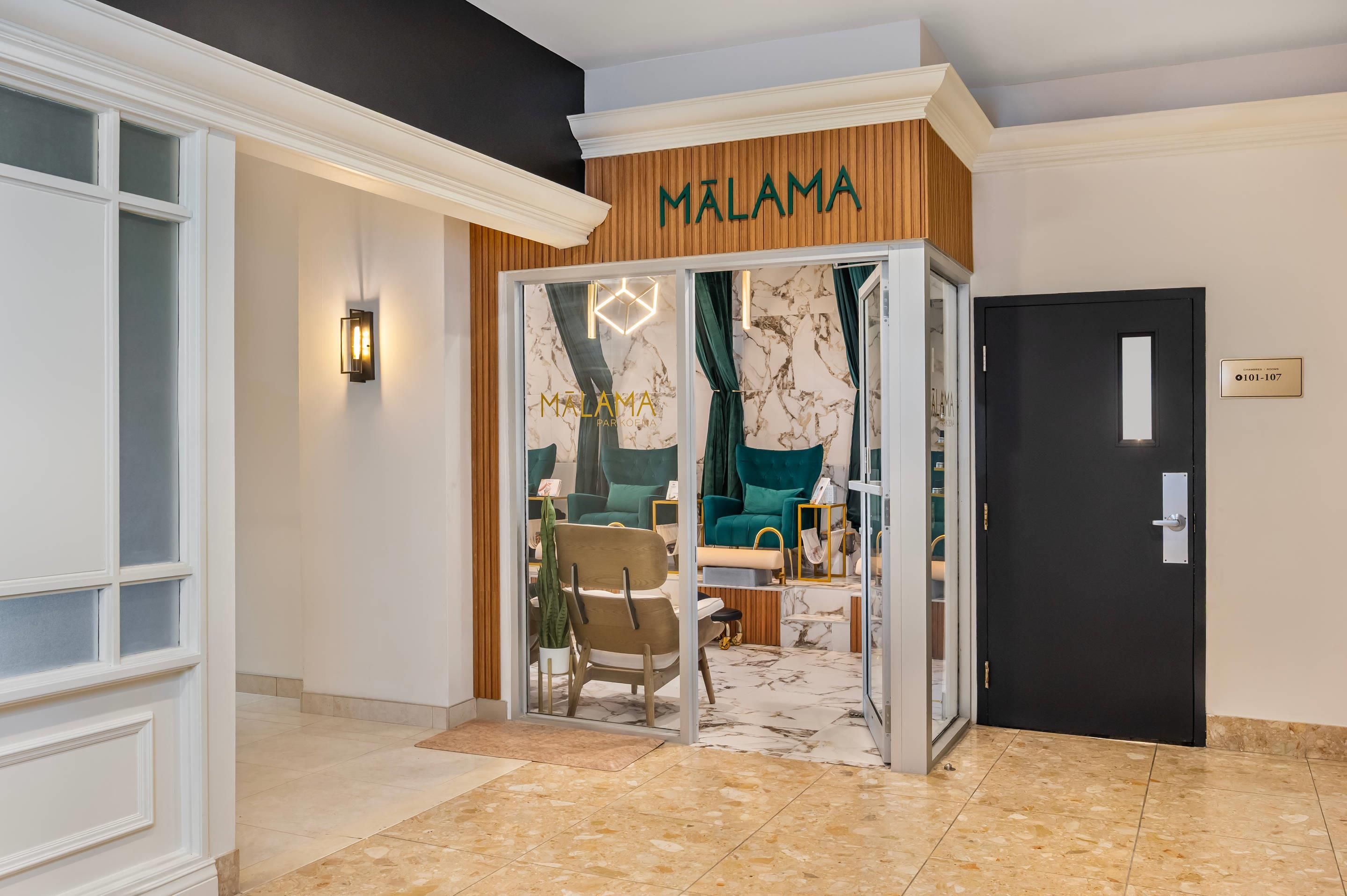 A hotel entrance with a sign reading 'MALAMA PARK KOEMA' and a door labeled '101-107'.