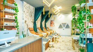 A salon with multiple treatment chairs, a reception desk, shelves with products, and a poster on the wall. - Chateau Cartier Hotel & Resort, an Ascend Collection Resort (Gatineau)
