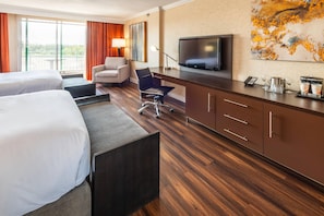 A hotel room with two beds, a desk, a TV, a chair, and a large window with curtains. - Chateau Cartier Hotel & Resort, an Ascend Collection Resort (Gatineau)