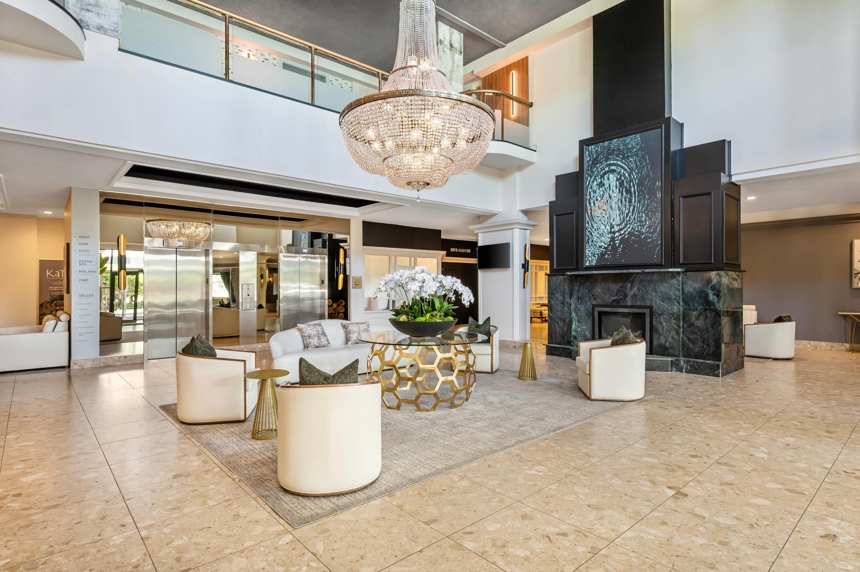 A spacious living area with a high ceiling, a chandelier, and a modern fireplace.