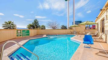 Relax by the pool surrounded by lounge chairs and umbrellas.