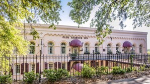 A historic building with arched windows and a sign reading "Olde Harbour Inn." - Olde Harbour Inn (Savannah)