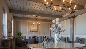 A modern lounge area with a round glass table, seating arrangements, and a decorative plant centerpiece. - Olde Harbour Inn (Savannah)
