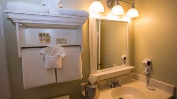 A bathroom with a sink, mirror, towel rack, and hairdryer.