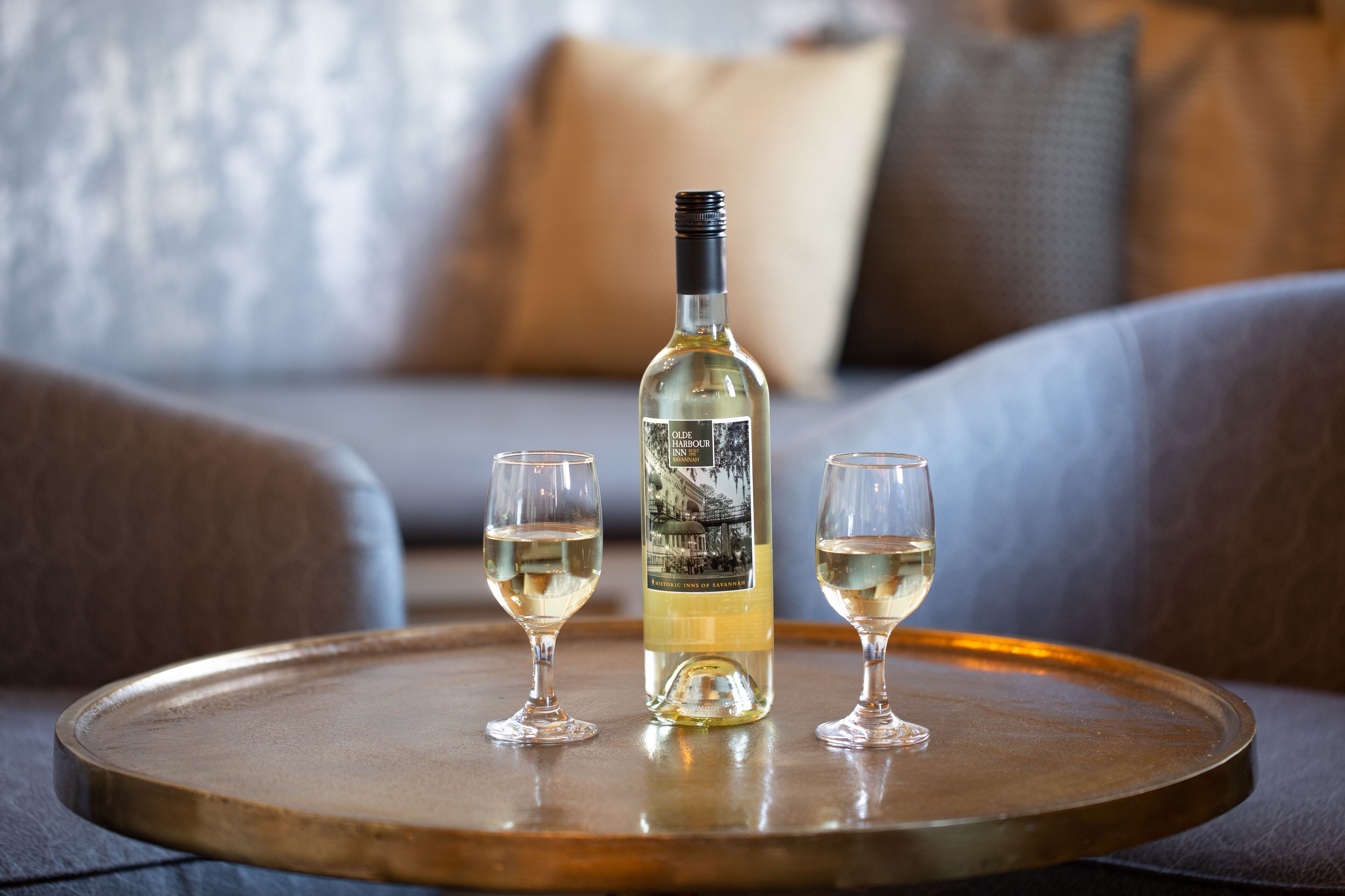 Une bouteille de vin et deux verres sur un plateau.