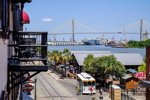 A street with a tram, a bridge in the background, and a sign for 'Joe's Crab Shack'.