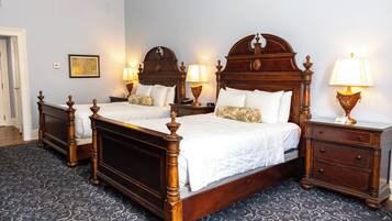 A double bed with a wooden headboard, two bedside tables with lamps, and a patterned carpet.