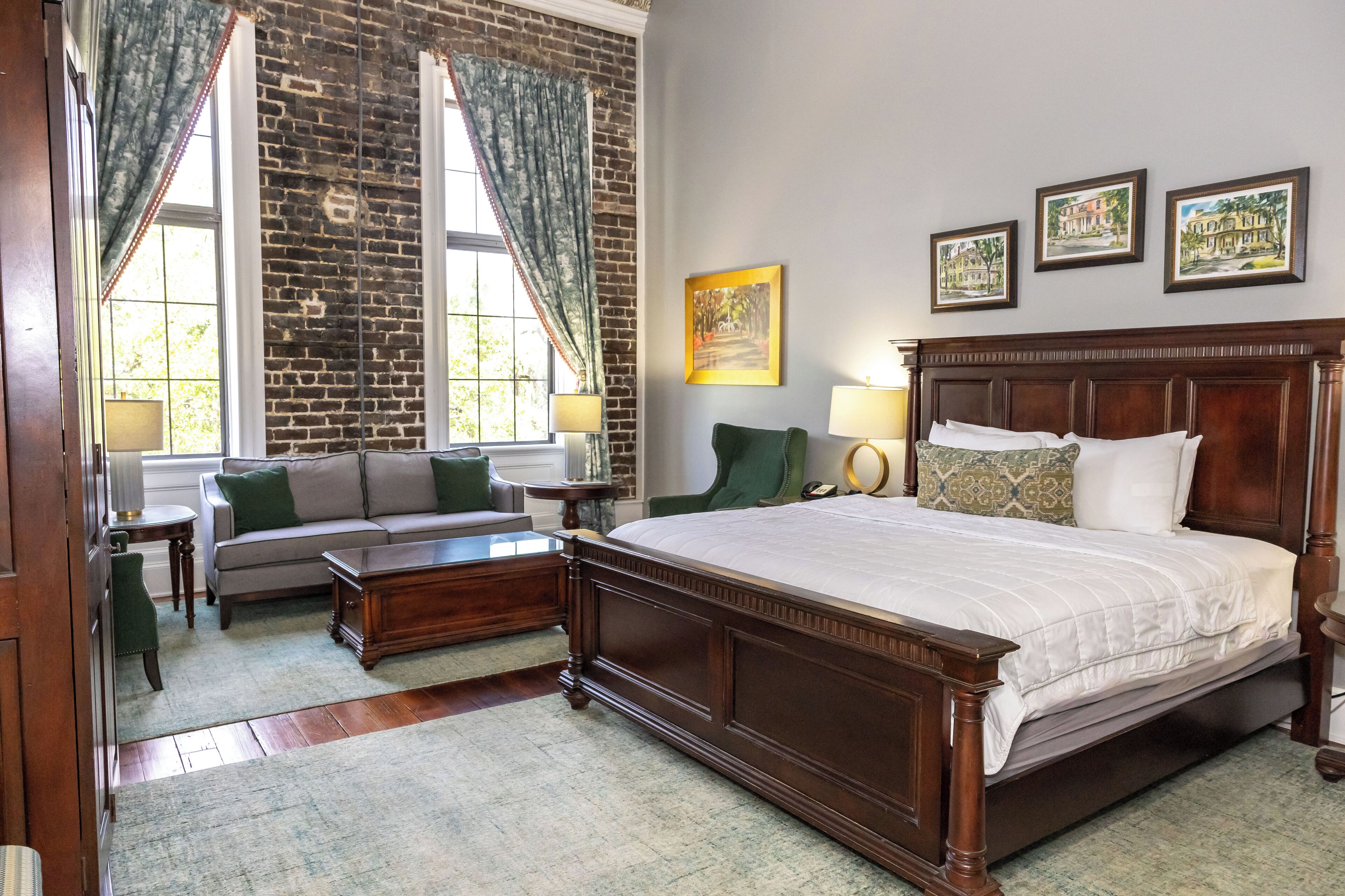 Une chambre avec un grand lit, un canapé, une table basse et une fenêtre avec des rideaux.