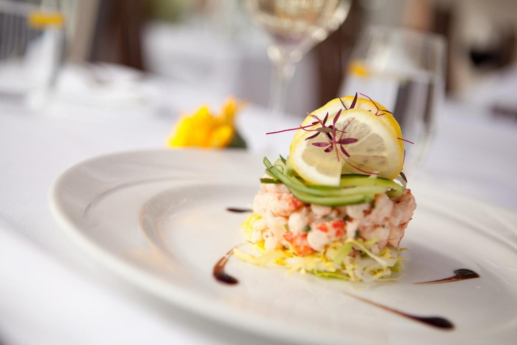 Un plato de mariscos sobre una vajilla blanca con guarnición decorativa.