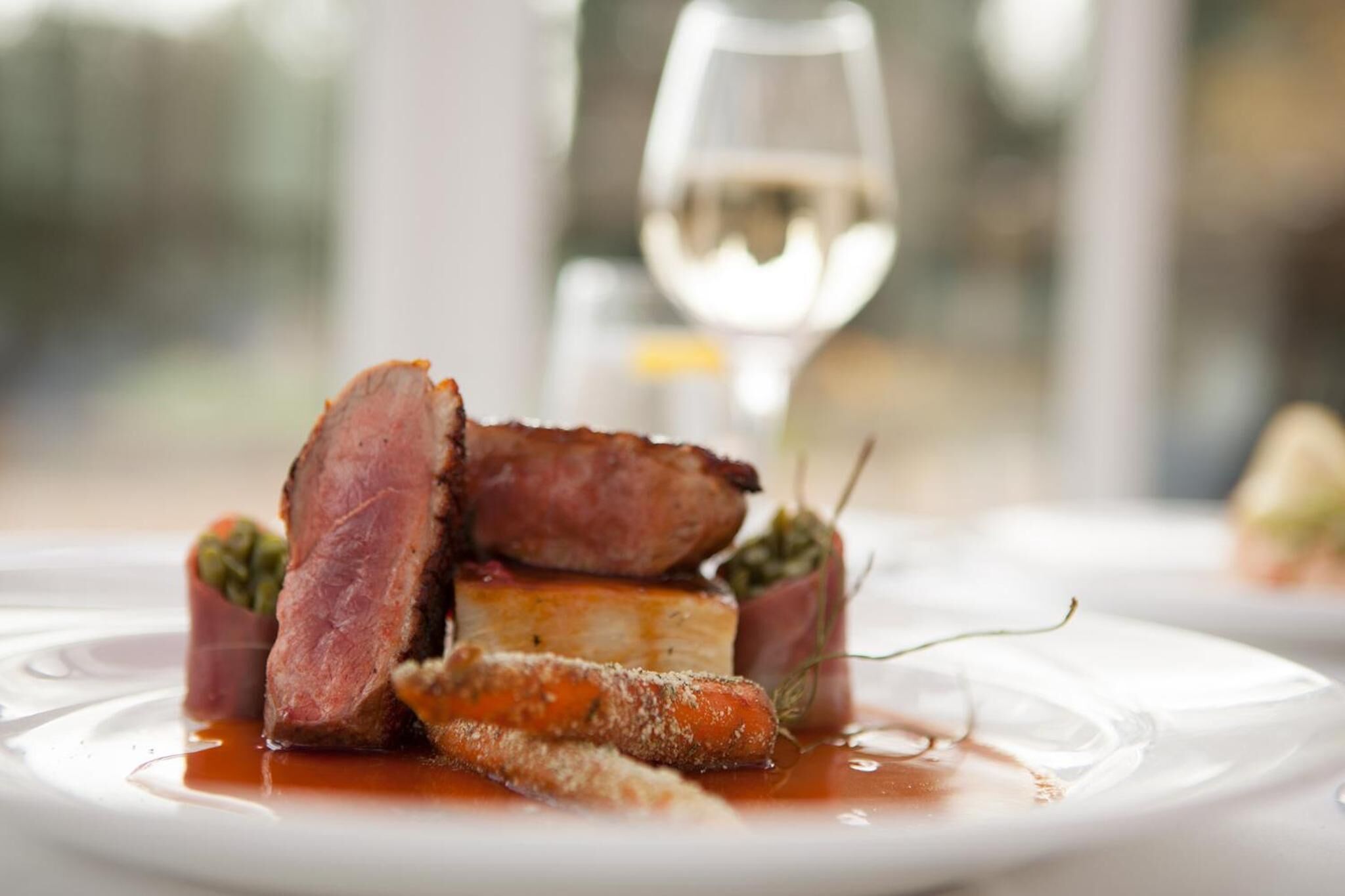 A plated dish with meat, vegetables, and sauce.