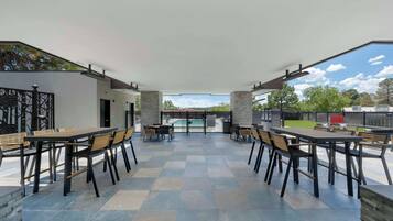 Relax and socialize in this outdoor patio area with a clear view of the swimming pool.
