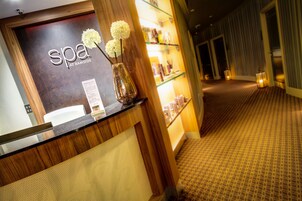 A reception area with a wooden counter, a sign reading "spa at Ramside," and a vase with flowers.