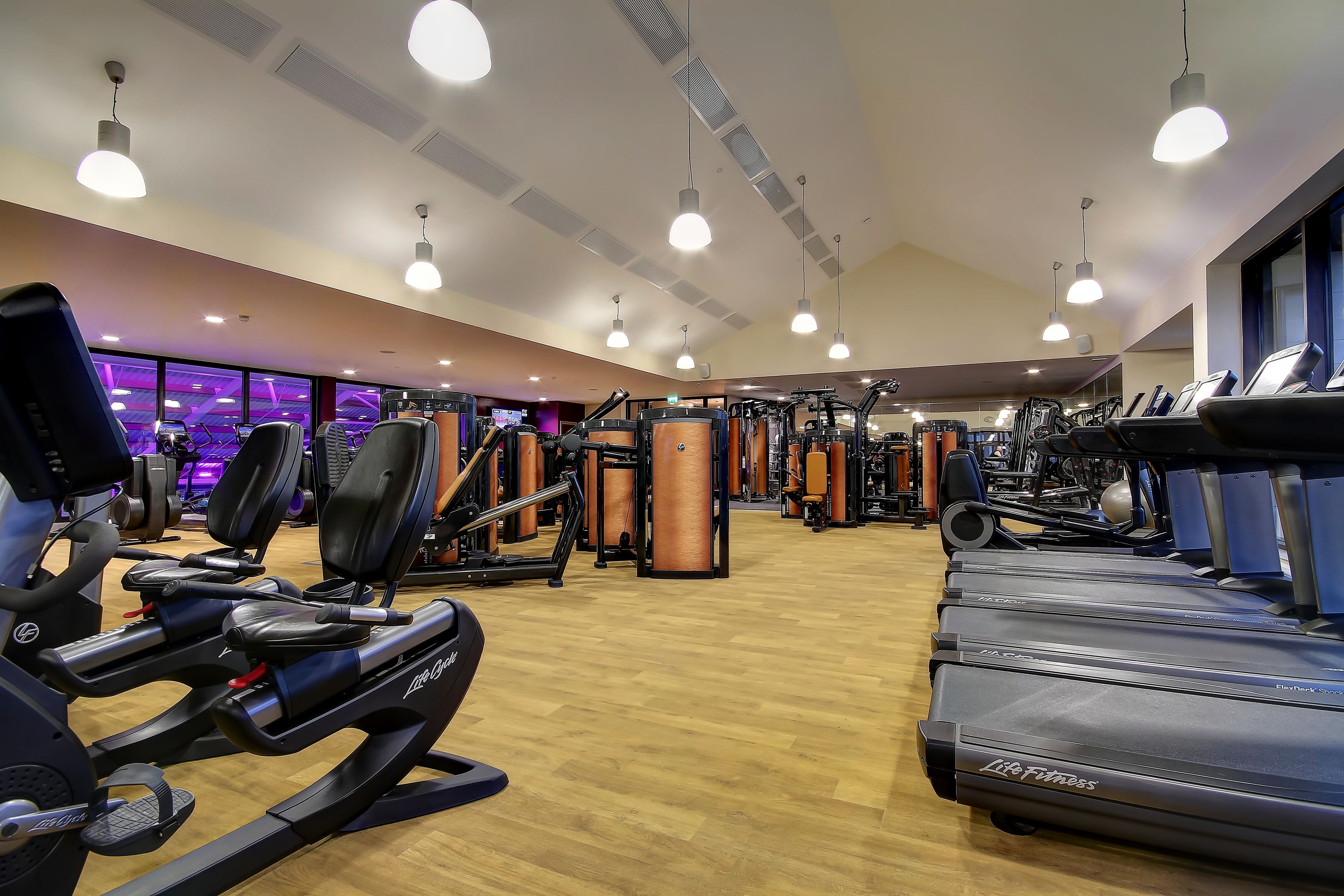 A gym with treadmills, weight machines, and exercise equipment.