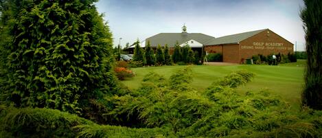 A golf academy with a driving range, shop, and lounge bar.