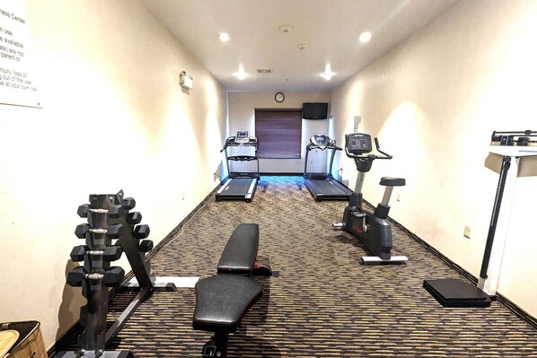 A hotel fitness center with treadmills, a stationary bike, a bench, and weight machines. - Ramada by Wyndham Prince Albert (Prince Albert)