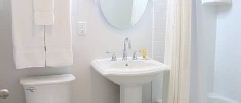 Un baño con inodoro, lavabo y ducha.