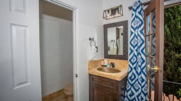 Une salle de bain avec un lavabo, un meuble-lavabo et un rideau de douche.