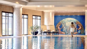 An indoor swimming pool with a mosaic wall and seating area. - Park Hyatt Melbourne (East Melbourne)