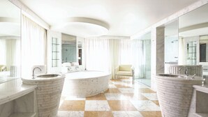A modern bathroom with a large central sink, two side sinks, and a round bathtub. - Park Hyatt Melbourne (East Melbourne)