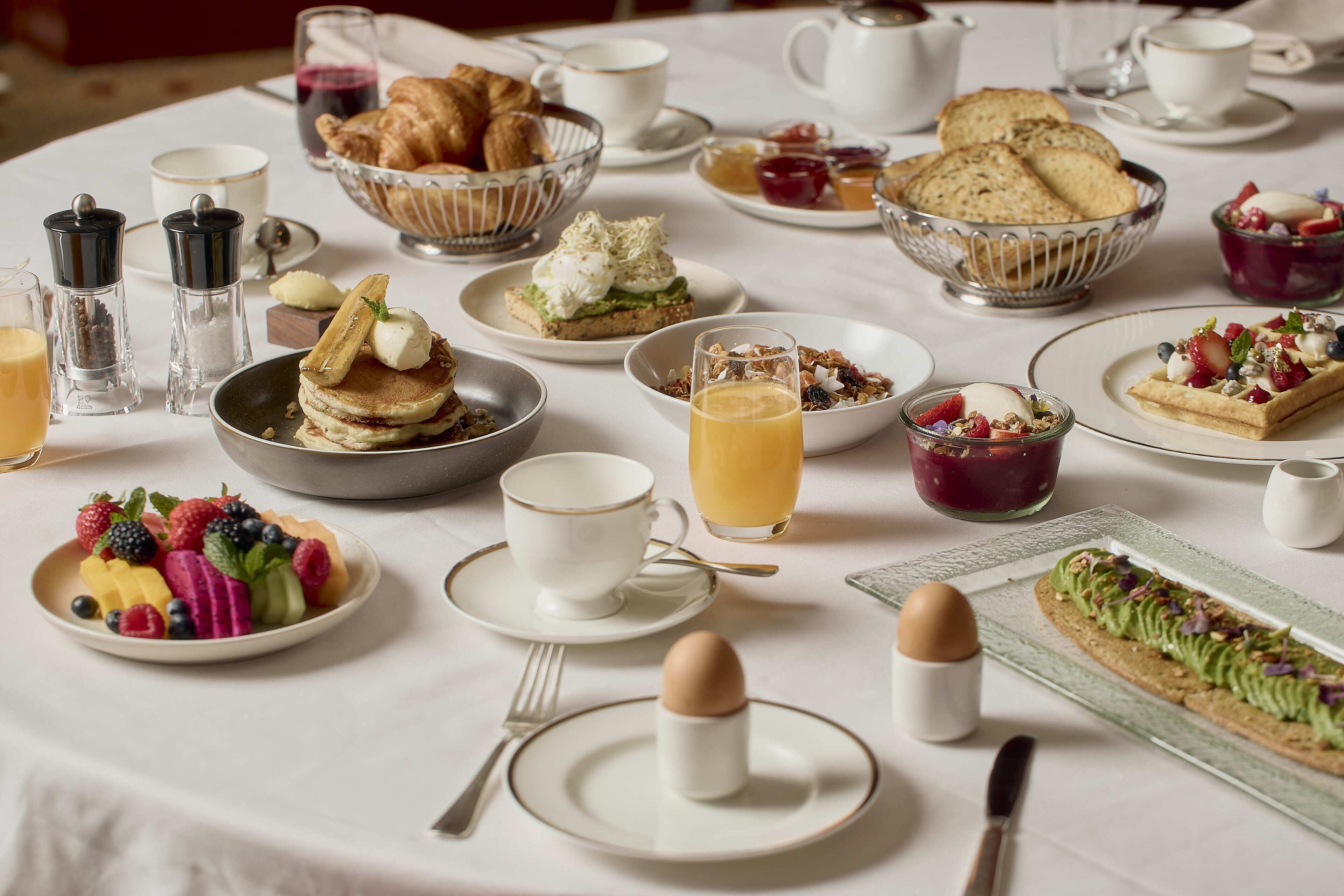 A breakfast buffet with various dishes and beverages.