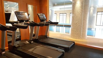 A gym with treadmills and a mirrored wall.