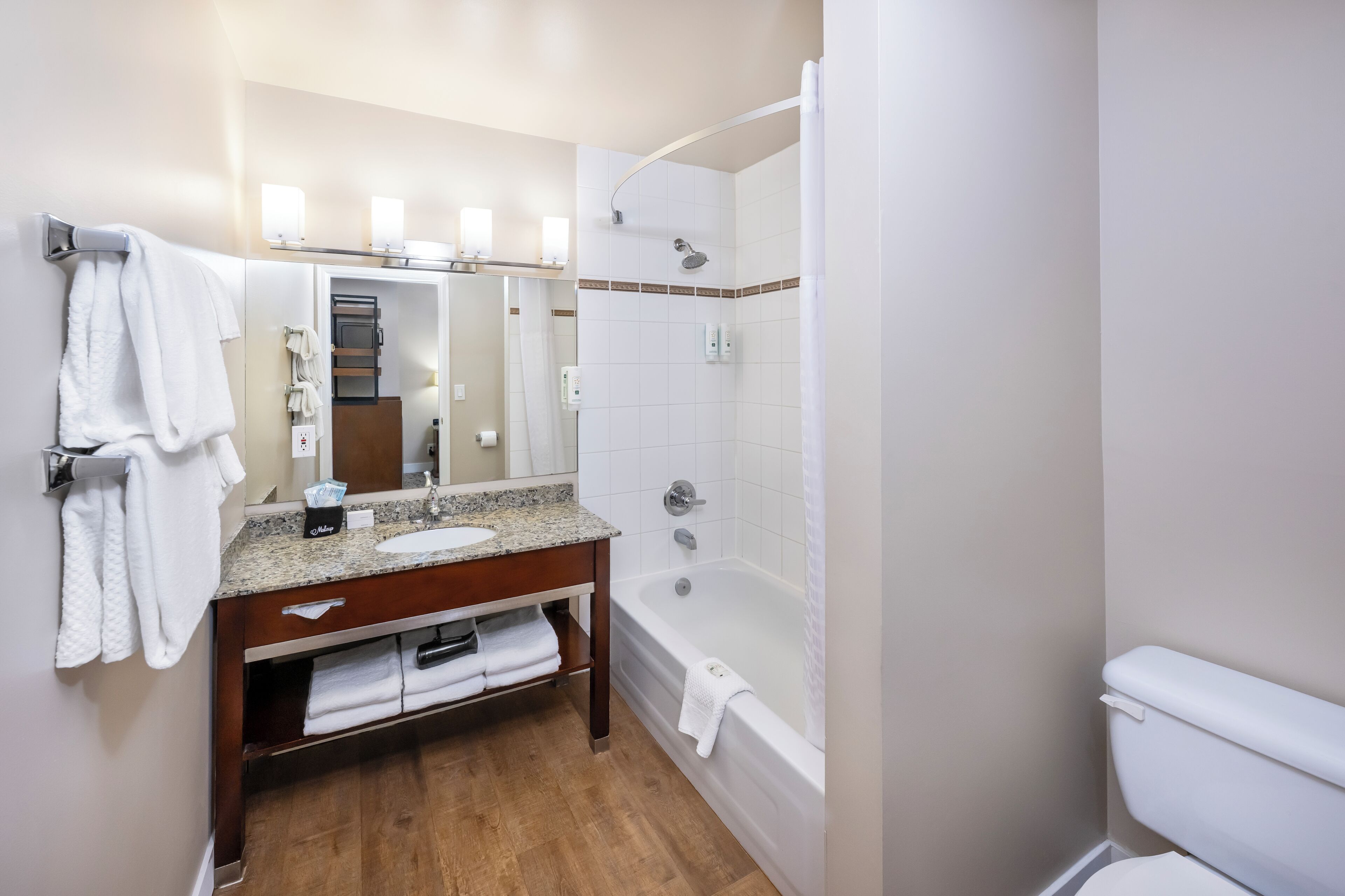 Une salle de bain équipée d’un lavabo, d’un miroir, d’un porte-serviettes et d’une baignoire.