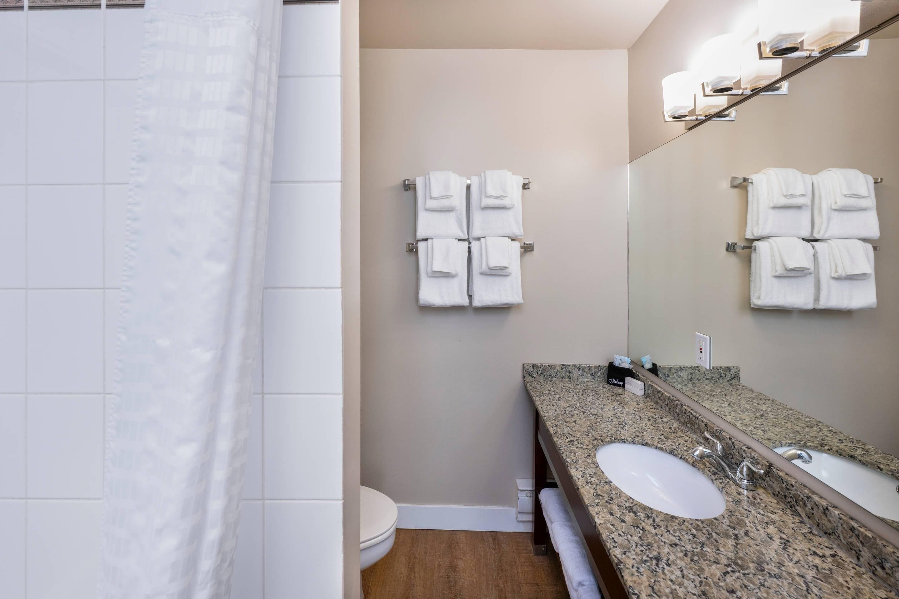 A bathroom with two sinks, a toilet, and a shower curtain.