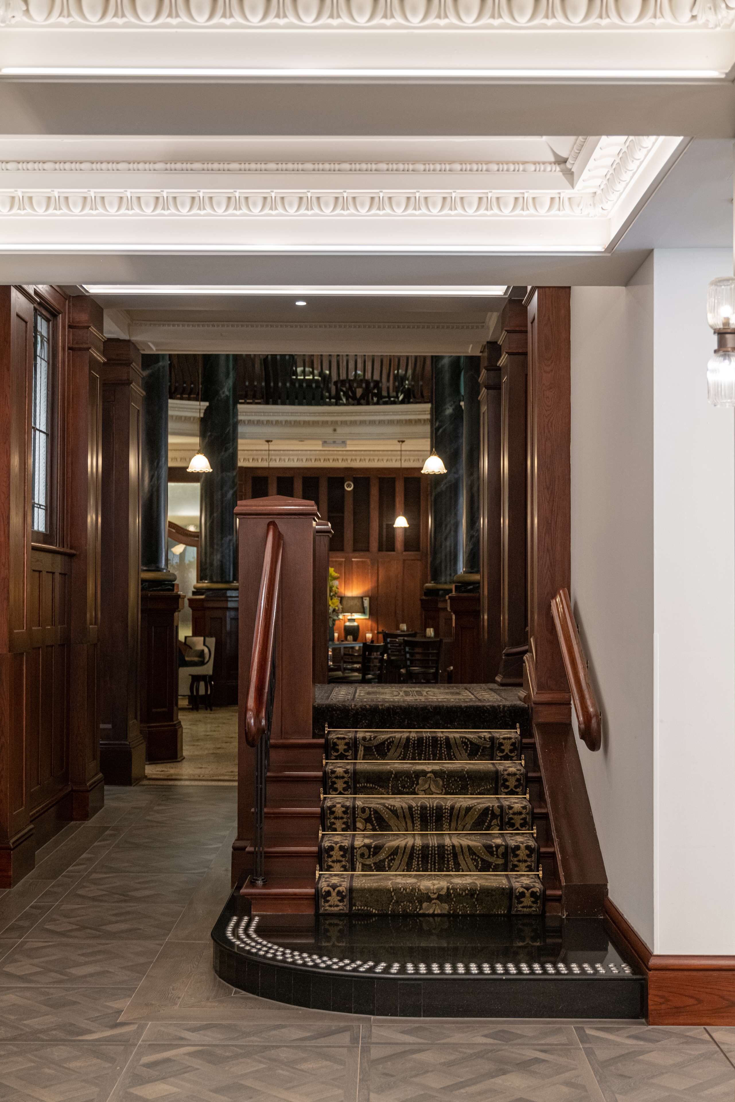 A grand staircase with ornate railings and a carpeted landing.