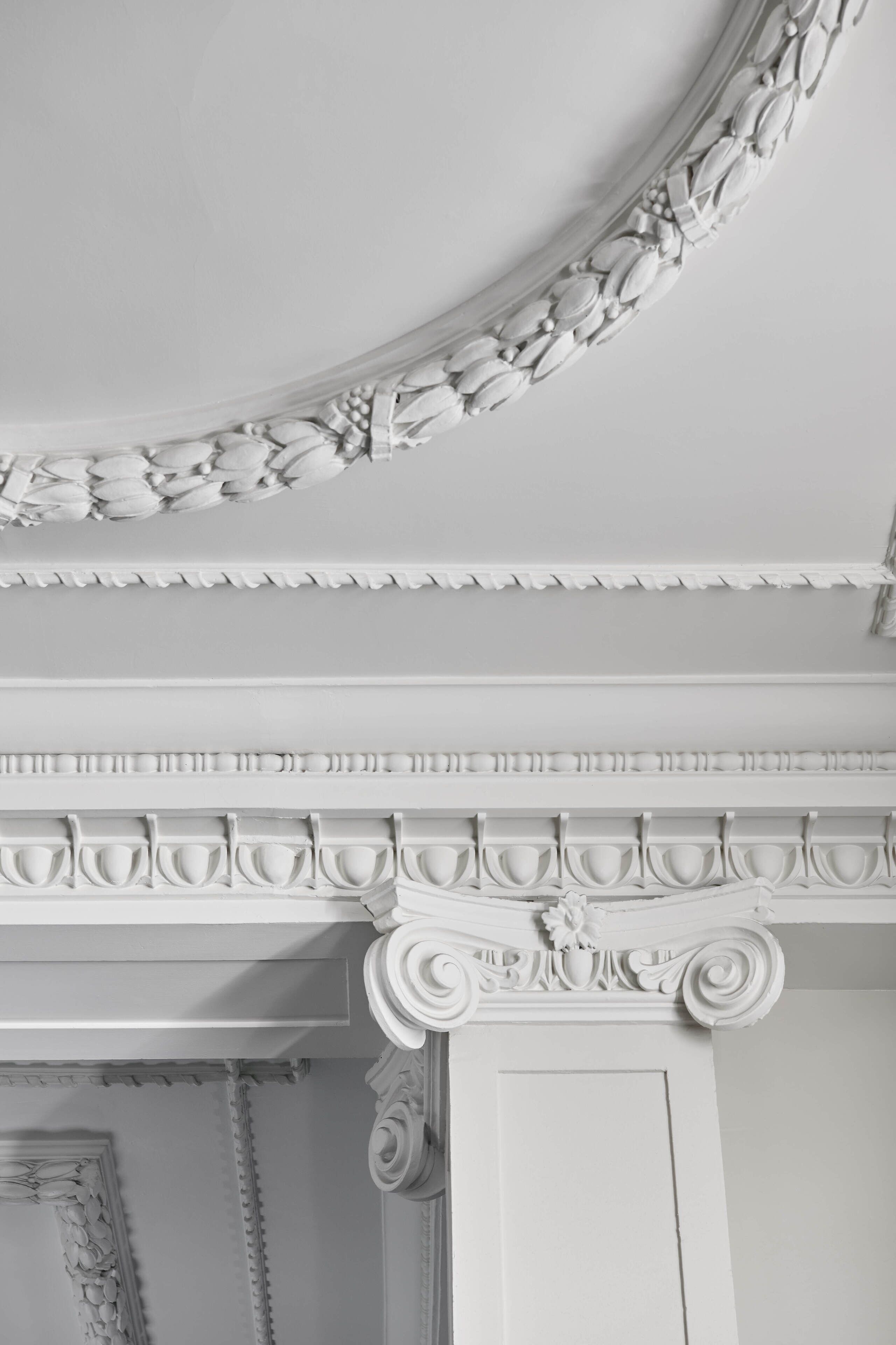 A white ornate ceiling with elaborate moldings and a decorative cornice.