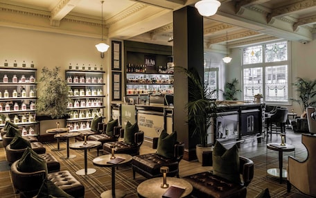 A bar area with leather seating and a variety of bottles on shelves.