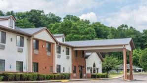 A two-story building with a covered entrance and a parking lot. - Super 8 by Wyndham Coshocton Roscoe Village (Coshocton)