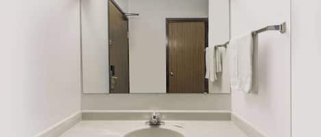 A bathroom with a white sink, a mirror, and a towel rack.