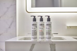 Three bottles of Rigilow conditioner, shampoo, and body lotion on a white bathroom counter.