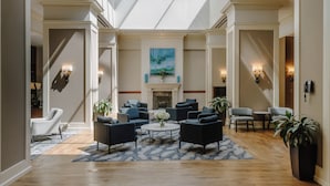 A spacious lobby with a high ceiling, a central fireplace, and multiple seating areas. - Club Quarters Hotel Rittenhouse Square, Philadelphia (Philadelphia)