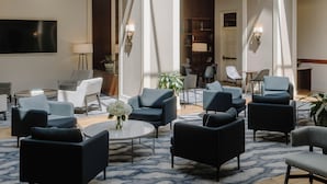 A spacious lobby with a high ceiling and skylight, featuring modern furniture and a central seating area. - Club Quarters Hotel Rittenhouse Square, Philadelphia (Philadelphia)