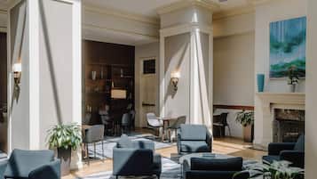 A spacious lobby with high ceilings, a fireplace, and a large painting.